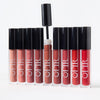 Assorted liquid lip glosses in neutral and red shades lined up with one wand open against a white background