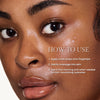 Close-up of a person with dewy skin showing instructions for product application: apply drops to fingertips, massage into skin, and use in the morning or as needed for hydration.