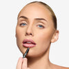 Model holding a lip liner to her mouth, showcasing a berrypink shade