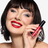 Model holding and showcasing a red lipstick