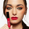 Model holding and showcasing a bright red lipstick