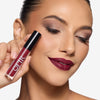Model holding and showcasing a wine shade lipstick