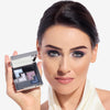 Model holding a shadow palette in one hand, with the shades applied to her eyes, showcasing a purple/cool makeup look