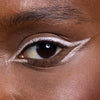 Close-up of a styled eye showcasing bold white eyeliner artfully applied, highlighting the shape of the eye for a striking and modern look.