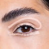 Close-up of an eye with precisely applied nude-colored eyeshadow and eyeliner, showcasing a creative makeup technique.
