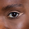 Close-up of a well-defined eye showcasing precise eyeliner application and natural eyebrows, emphasizing skincare and eye makeup.