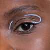 Close-up of an eye with creative white eyeliner design applied above and below the eyelid.