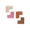 Four swatches of crushed eyeshadow in pearly white, pink, copper, and brown shades, arranged in a grid pattern on a white background.