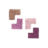 Four swatches of crushed eyeshadow powders in metallic bronze, lavender, light pink, and deep plum arranged in L-shapes against a white background.