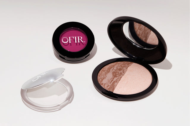 Three makeup products featuring a vibrant pink blush, a dual-tone bronzer with a mirror, and a compact with a reflective surface.