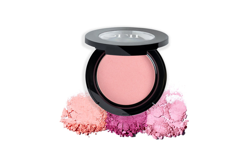 A compact of pink blush with its black casing open, showcasing finely milled powders in soft peach, vibrant pink, and light purple hues.
