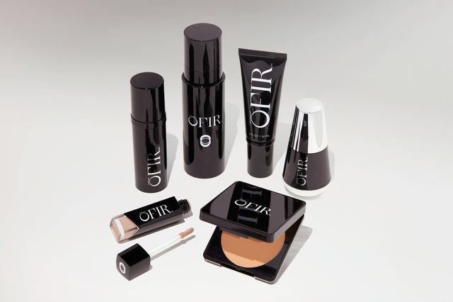 Elegant black and white cosmetic packaging showcasing a variety of beauty products, including foundation, concealer, and skincare tubes, arranged neatly.