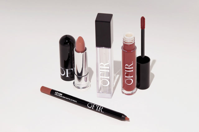 Collection of OFIR lip products featuring a nude lipstick, a clear lip gloss, a deep red liquid lipstick, and a long-wear demi-matte lip pencil.