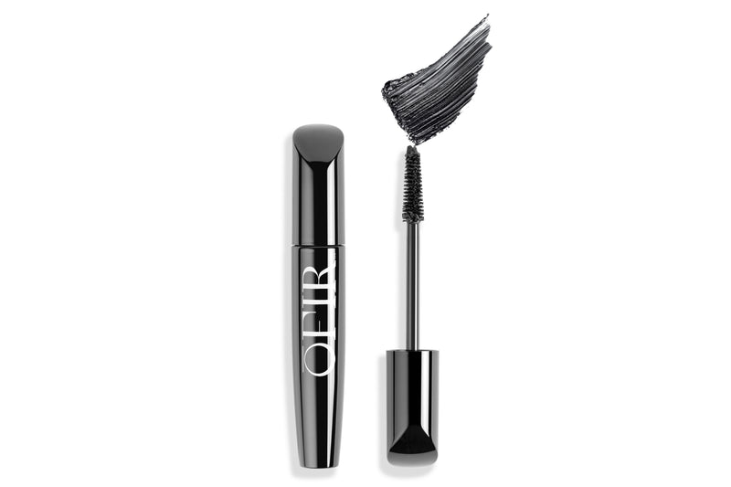 Black mascara tube and wand with a bold swatch of mascara nearby, showcasing its application and finish.