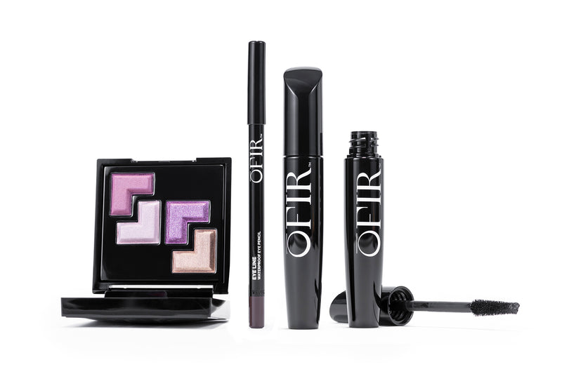 A sleek beauty set including a palette with four shimmering eyeshadows in pink and purple hues, an eyeliner pencil, and a mascara tube with a brush, all branded with the name "OFIR".
