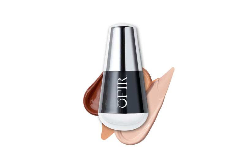 A sleek black and silver bottle labeled "OFIR" is surrounded by swatches of foundation in three different shades, ranging from light to dark.