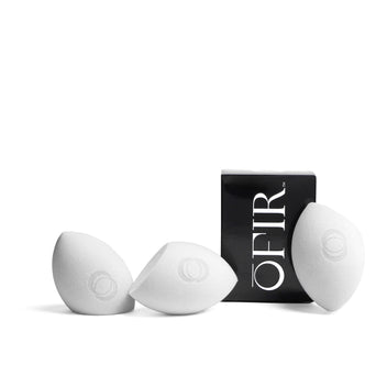 Three white makeup sponges are displayed alongside a black box labeled "OFIR," showcasing a sleek and modern design.